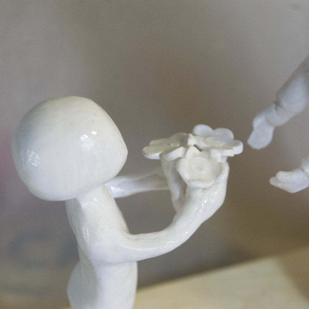 Enfant qui remet des fleurs à sa maman